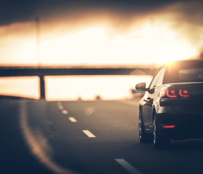 Highway Car Trip. Small Compact Car on the Highway During Sunset.